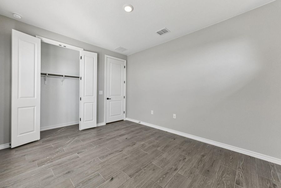 Unfurnished bedroom featuring wood finished floors, recessed lighting, and a closet Unfurnished bedroom featuring wood finished floors, recessed lighting, and a closet