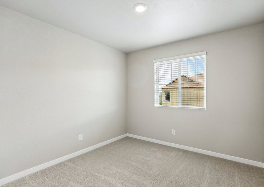 The secondary bedroom has a large window and carpet. The secondary bedroom has a large window and carpet.