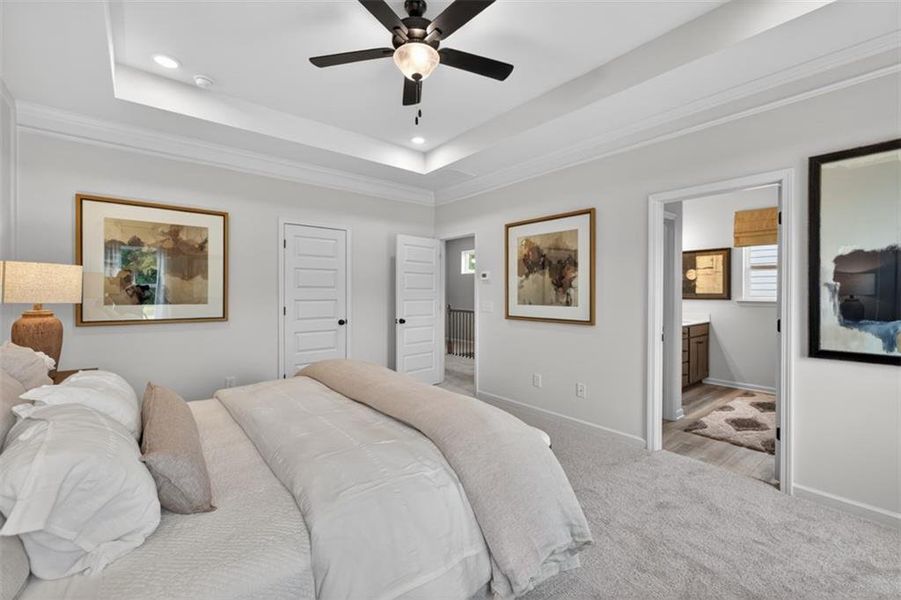 Carpeted room featuring a tray ceiling with recessed lighting and a ceiling fan