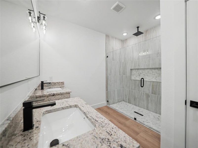 Spacious bathroom featuring a dual vanity with granite countertops, undermount sinks, and matte black fixtures Spacious bathroom featuring a dual vanity with granite countertops, undermount sinks, and matte black fixtures