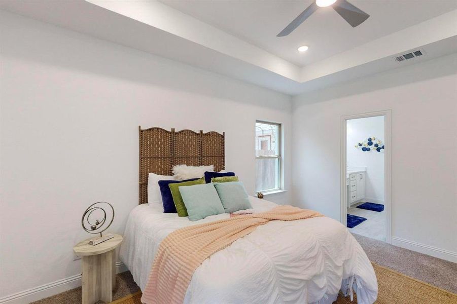 Main Bedroom with ceiling fan, light carpet, and ensuite bath