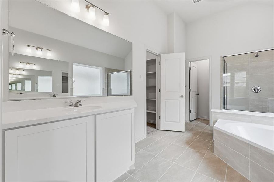 Modern bathroom featuring a single vanity with white cabinetry and a large mirror