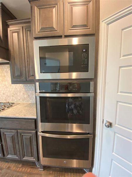 Kitchen features built-in stainless double ovens & microwave