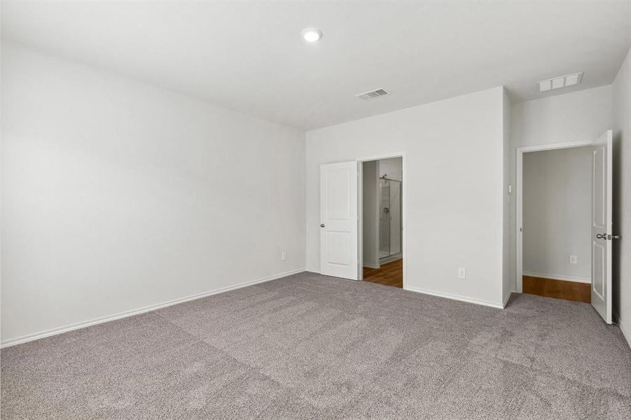 Spacious room featuring neutral carpeting, white walls, and recessed lighting