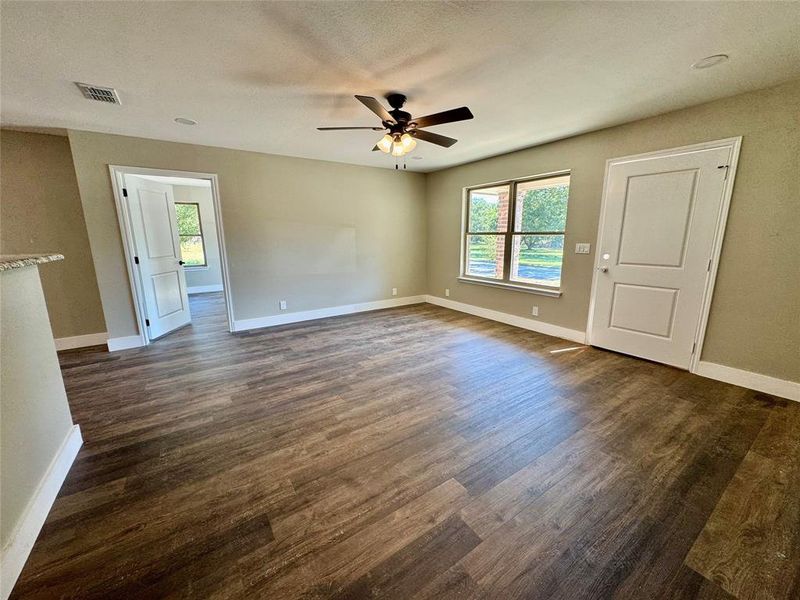 Unfurnished room featuring dark wood finished floors, ceiling fan, and a textured ceiling