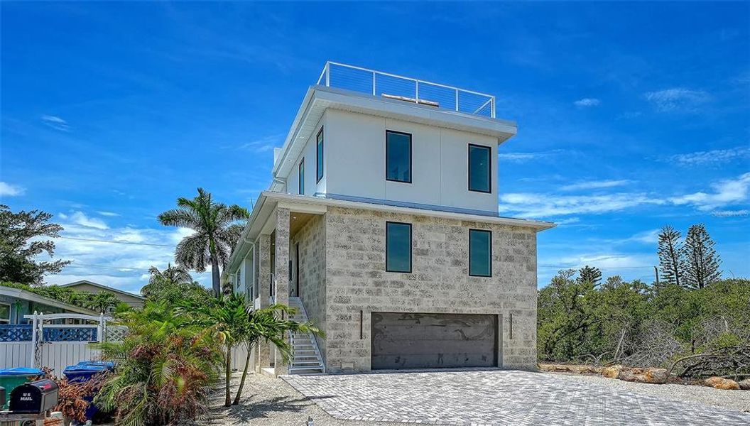 Front exterior of a new home in , Holmes Beach, FL, highlighting curb appeal (Image 1). Front exterior of a new home in , Holmes Beach, FL, highlighting curb appeal (Image 1).