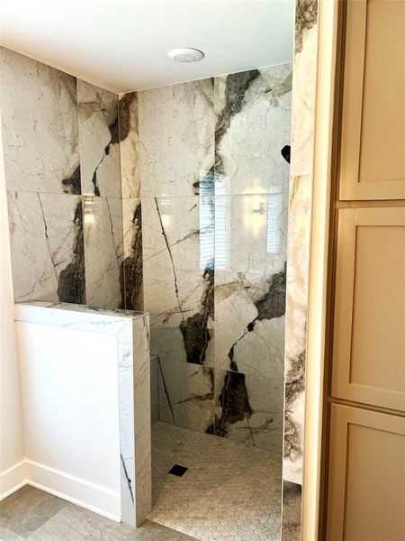 Full bath with a marble finish shower Full bath with a marble finish shower