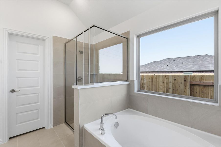 Full bath featuring a bath, a shower stall, and light tile patterned floors