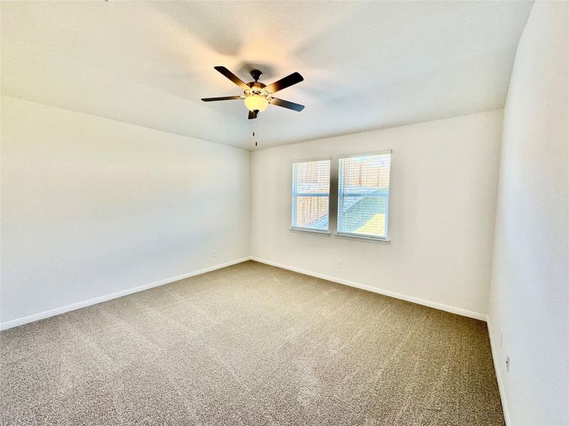 Empty room with carpet floors and ceiling fan