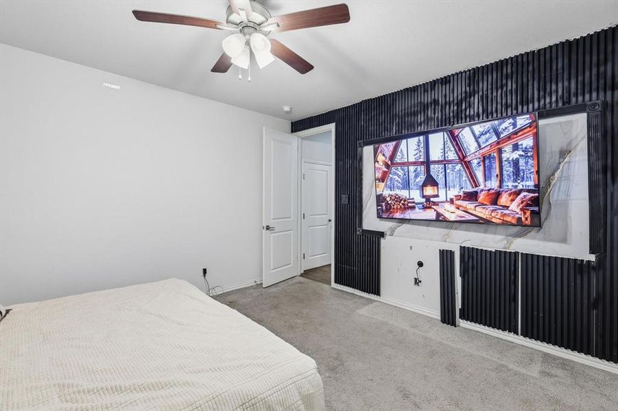 Carpeted bedroom featuring a ceiling fan and baseboards