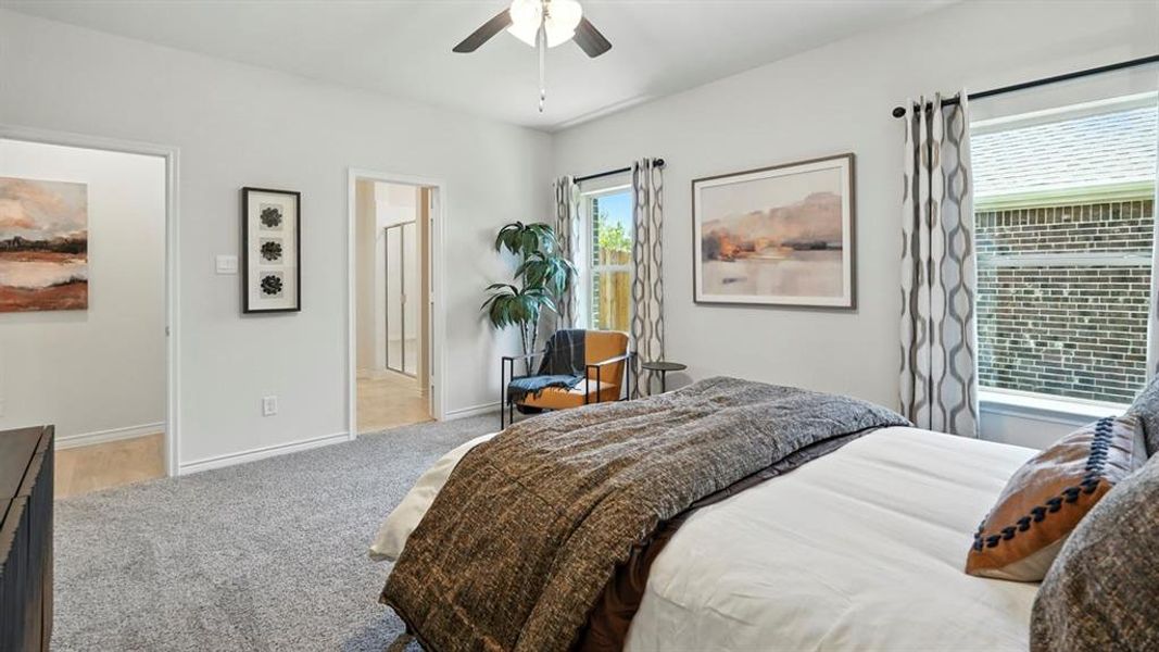 Bedroom featuring light colored carpet, ceiling fan, and ensuite bath