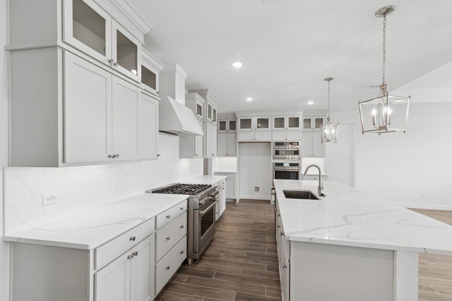 Stunning light grey stacked cabinets and quartz countertops in the kitchen