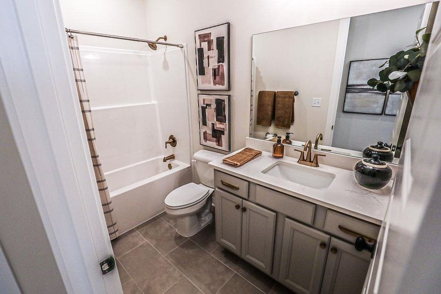 Full bath with vanity, shower / bathtub combination with curtain, and dark tile patterned flooring