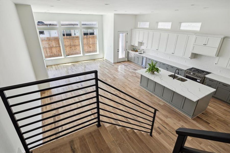 View of living and dining space from the landing. Hand forged wrought iron staircase runs throughout the home