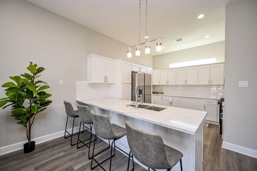 Sleek modern kitchen featuring a spacious peninsula and stylish pendant lighting.