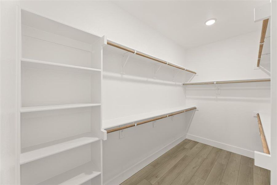 Spacious closet featuring light wood-style floors Spacious closet featuring light wood-style floors