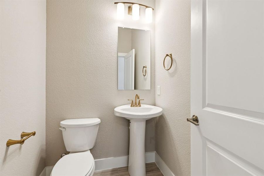 Bathroom featuring a textured wall and wood finished floors
