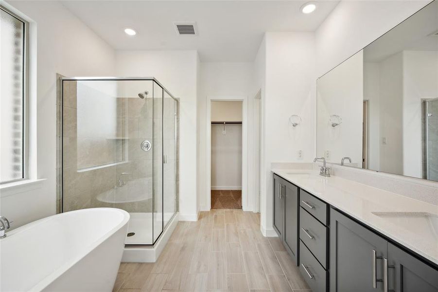 Bathroom featuring tile patterned floors, dual bowl vanity, and separate shower and tub