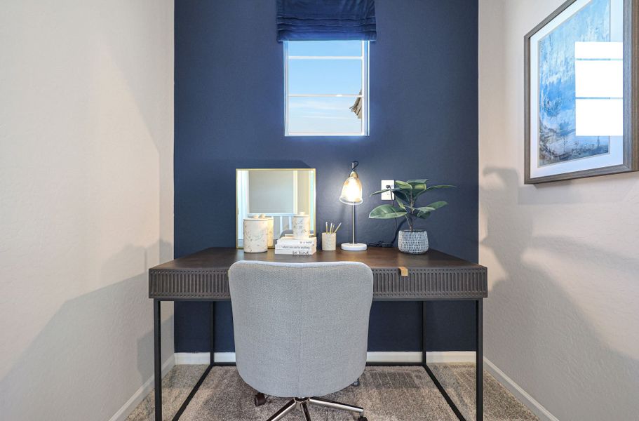A desk with a chair and a lamp on it.