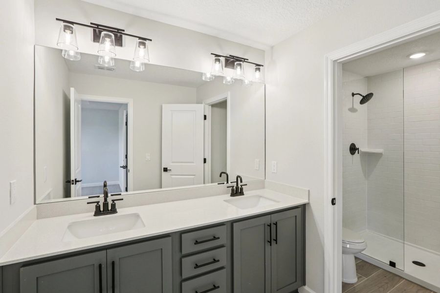 Primary bathroom with double sinks and a frameless walk-in shower featuring aspects of AW Collection® Minimalist -  Representative images and renderings are for illustrative purposes