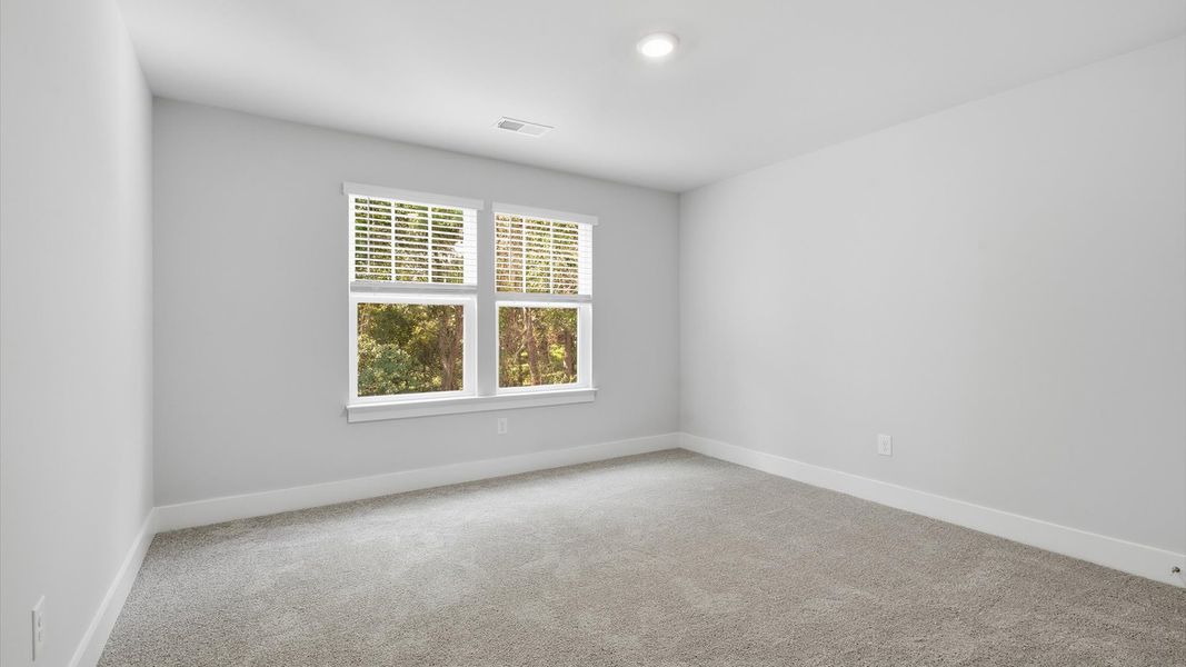 First-class secondary bedroom with comfortable carpeted flooring and generous closet space