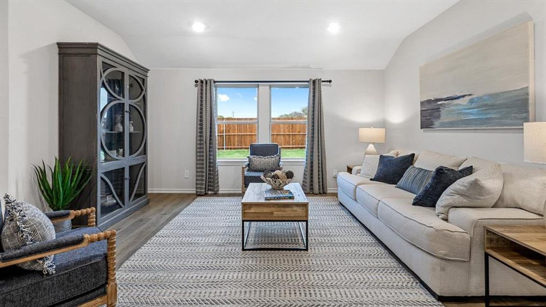 Living area featuring vaulted ceiling, wood finished floors, and recessed lighting Living area featuring vaulted ceiling, wood finished floors, and recessed lighting