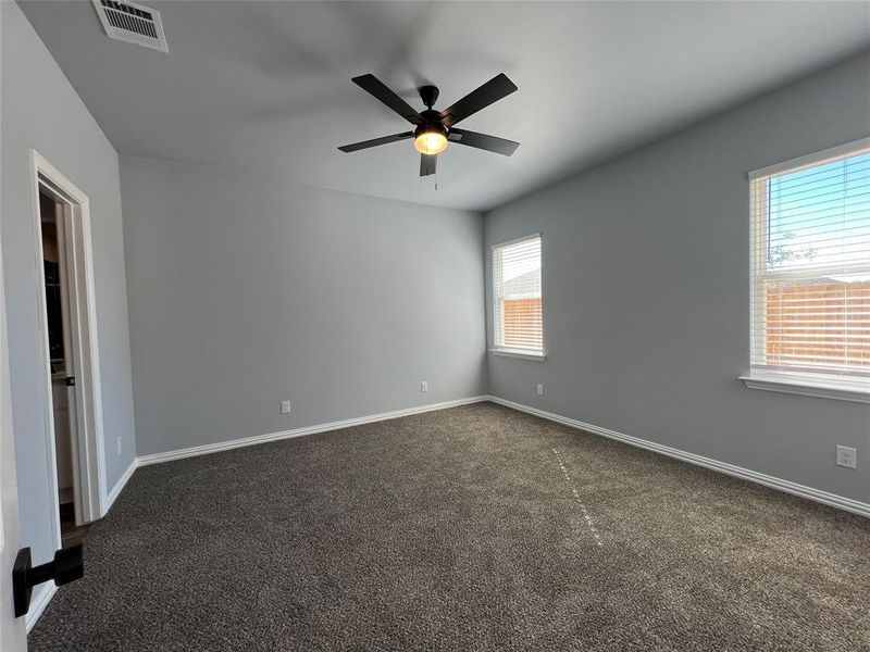 Carpeted empty room with ceiling fan