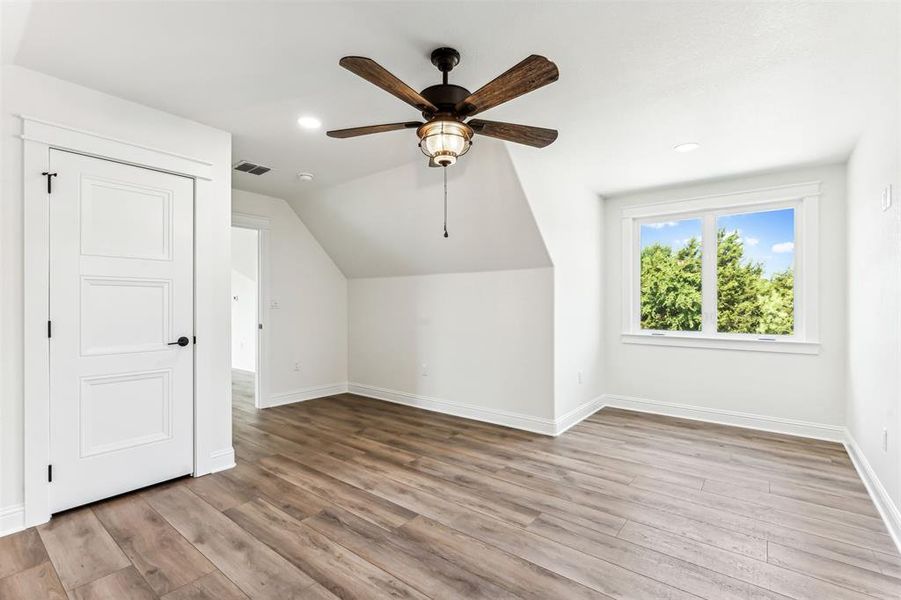 Bedroom 4 featuring vaulted ceiling, ceiling fan, light wood-type flooring, and private bathroom