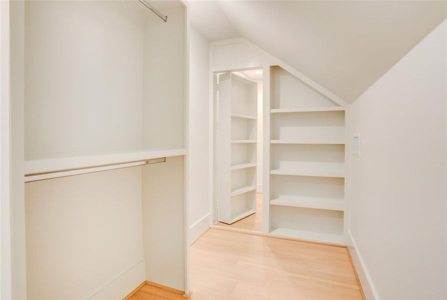 Secondary bedroom closet with additional conditioned storage behind the bookcase door. Perfect for out of season items or a small workout room.