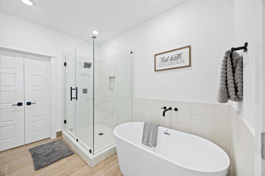 A spacious walk-in shower and a luxurious soaking tub invites relaxation, framed by tasteful tilework that enhances the serene ambiance. A spacious walk-in shower and a luxurious soaking tub invites relaxation, framed by tasteful tilework that enhances the serene ambiance.