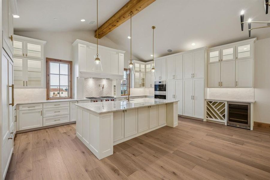 Kitchen featuring glass insert cabinets, white cabinetry, wine cooler, light stone counters, and light wood-style floors