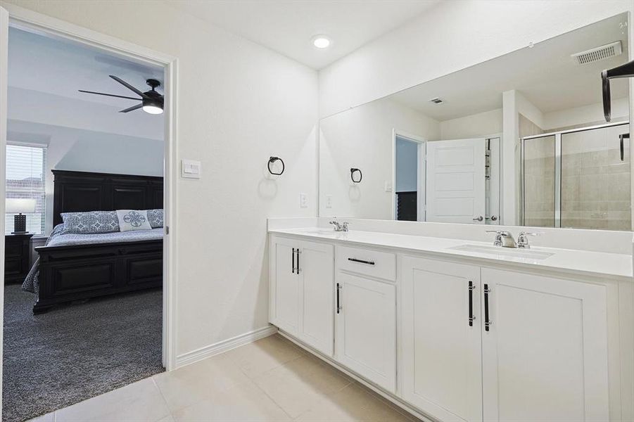 Bathroom with ceiling fan, tile patterned floors, vanity, and a shower with door