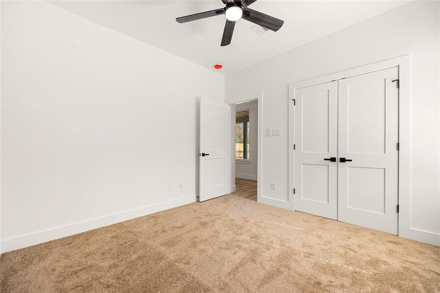 Comfortable Secondary BedroomThis inviting bedroom features a spacious double-door closet, plush carpeting, and a sleek ceiling fan. With a neutral color palette and natural light, this room offers a cozy and versatile space for any need!