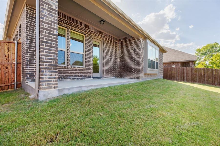 Back of house with brick siding and a patio