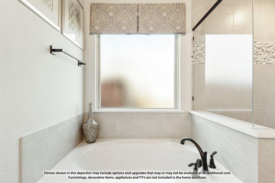 Bathroom with soaking tub, tile surround, frosted window, and glass shower enclosure nearby