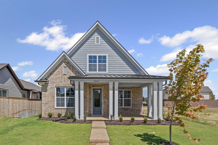 View of front of property with brick siding, a standing seam roof, covered porch, and a metal roof View of front of property with brick siding, a standing seam roof, covered porch, and a metal roof