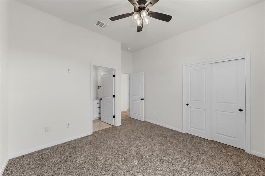 Unfurnished bedroom featuring carpet floors, a closet, and ceiling fan