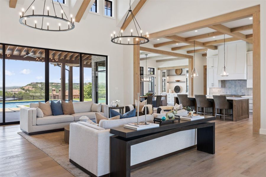 Living area with beamed ceiling, plenty of natural light, light wood-style flooring, a chandelier, and recessed lighting