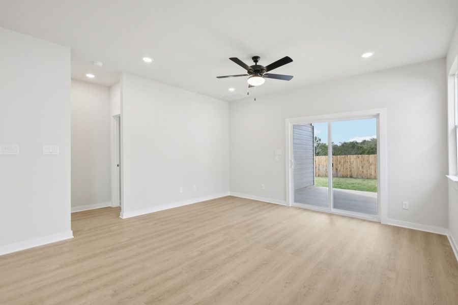 A room with a wood floor and a ceiling fan.