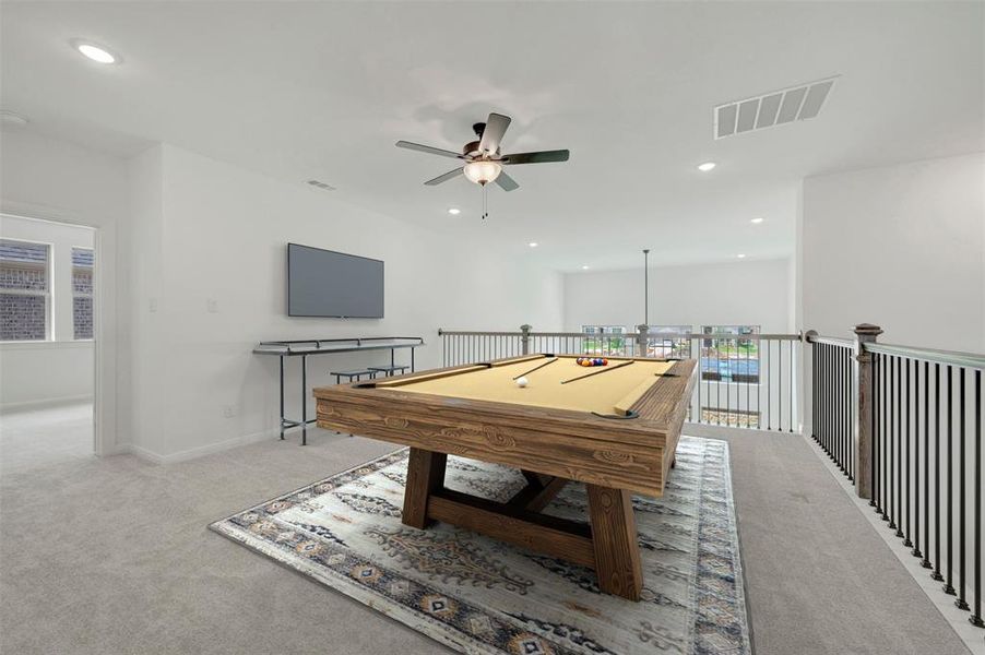 Open loft space with light-toned carpeting and a ceiling fan Open loft space with light-toned carpeting and a ceiling fan
