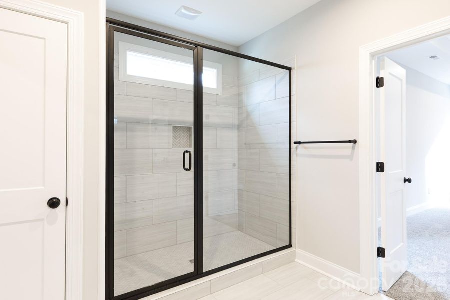 Walk-in tiled shower in primary bath. Walk-in tiled shower in primary bath.
