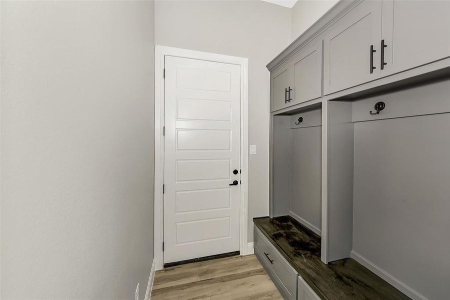Mudroom with light wood-style floors and baseboards