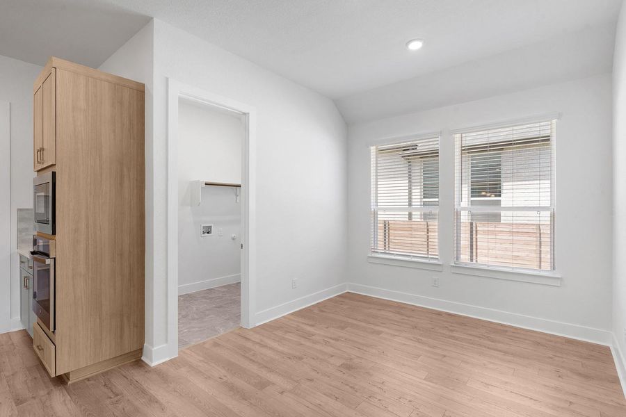 Blinds adorn dual windows in this naturally illuminated space featuring elegant wood flooring.