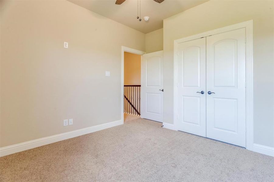 Unfurnished bedroom with light colored carpet, a closet, and ceiling fan