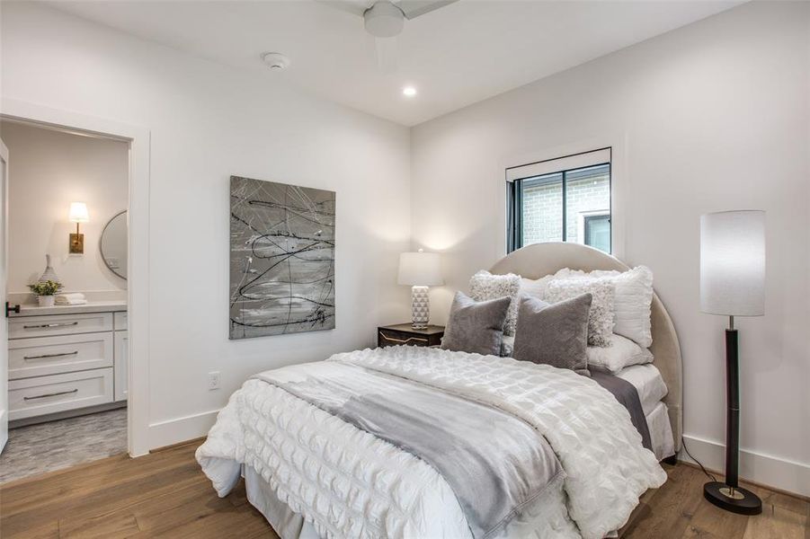 Bedroom with ceiling fan, dark hardwoo floors, and ensuite bathroom