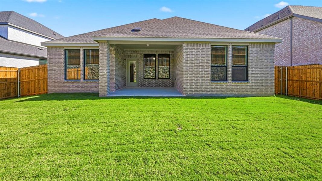 Rear view of house with a fenced backyard, a patio area, brick siding, and a shingled roof Rear view of house with a fenced backyard, a patio area, brick siding, and a shingled roof