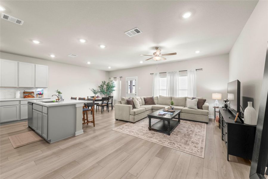 An open-concept living area features abundant natural light, flowing seamlessly from the kitchen and dining space. An open-concept living area features abundant natural light, flowing seamlessly from the kitchen and dining space.