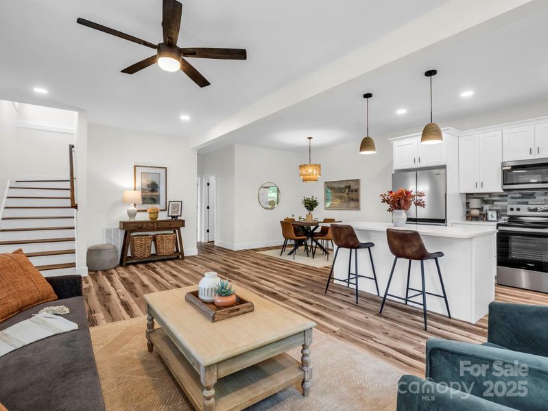 Looking from front right corner into the open floor plan, stairs to the left of front door