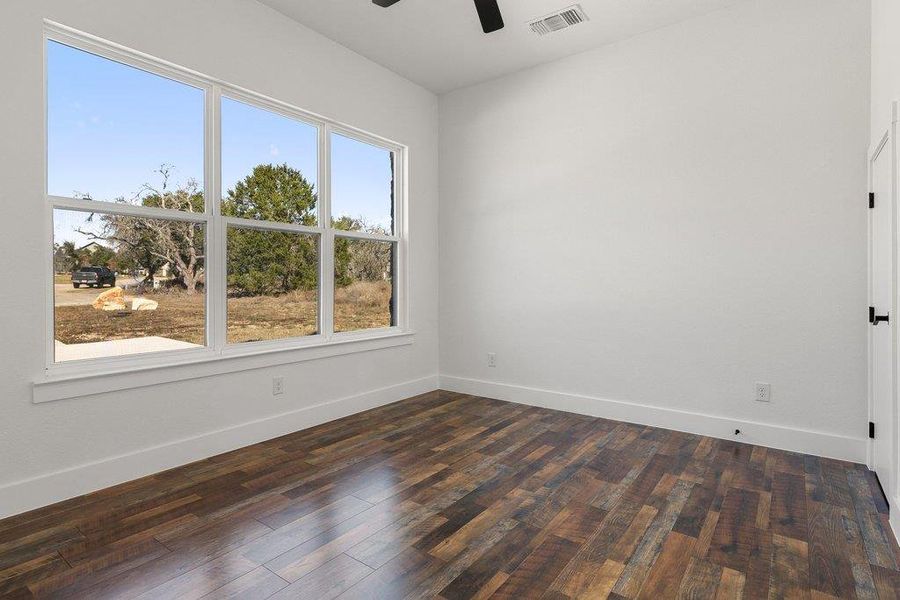 Spare room with dark wood finished floors and ceiling fan