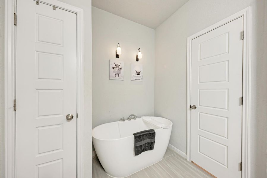 Bathroom with a soaking tub and tile patterned flooring